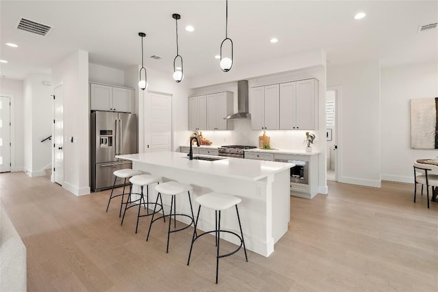 1702 Pennsylvania Ave, Austin, TX 78702 - kitchen with high quality appliances, a sink, wall chimney exhaust hood, a kitchen bar, and recessed lighting