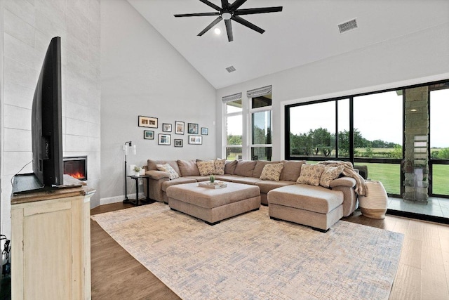 209 Northcrest Dr, Liberty Hill, TX 78642 - living area featuring high vaulted ceiling, ceiling fan, a fireplace, wood finished floors, and baseboards
