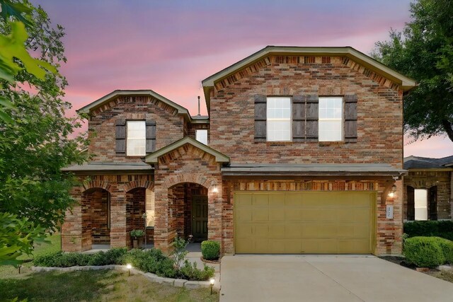 6900 Longford Trl, Austin, TX 78754 - view of front facade featuring brick siding, an attached garage, and driveway
