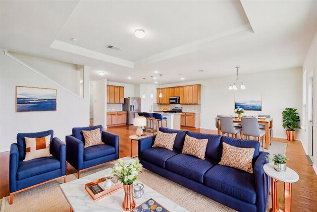 6900 Longford Trl, Austin, TX 78754 - living area with a tray ceiling, light wood-style floors, a chandelier, and recessed lighting