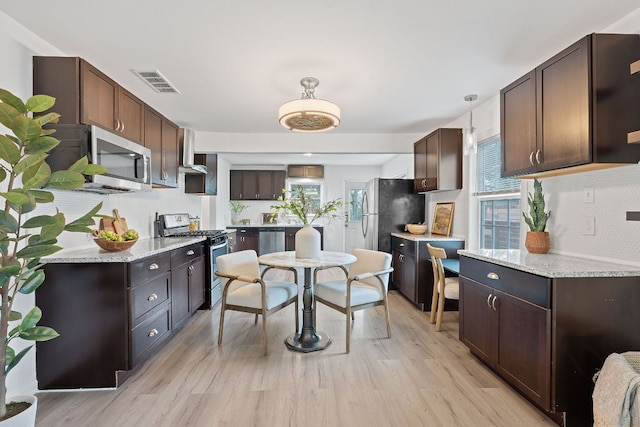 1156 Nickols Ave, Austin, TX 78721 - kitchen featuring stainless steel appliances, tasteful backsplash, dark brown cabinets, light wood finished floors, and hanging light fixtures