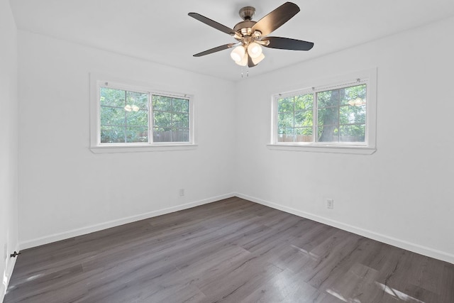 spare room with dark wood finished floors, baseboards, and a ceiling fan