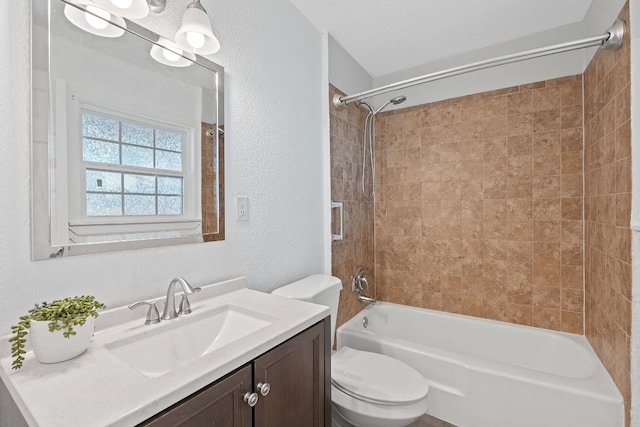 bathroom featuring a textured wall, toilet,  shower combination, and vanity