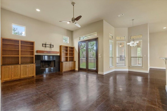 unfurnished living room featuring a fireplace, a chandelier, ceiling fan, baseboards, and recessed lighting