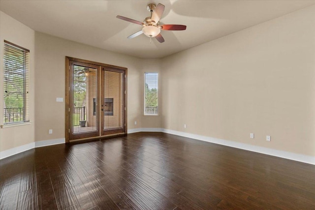 spare room featuring wood finished floors, a ceiling fan, and baseboards