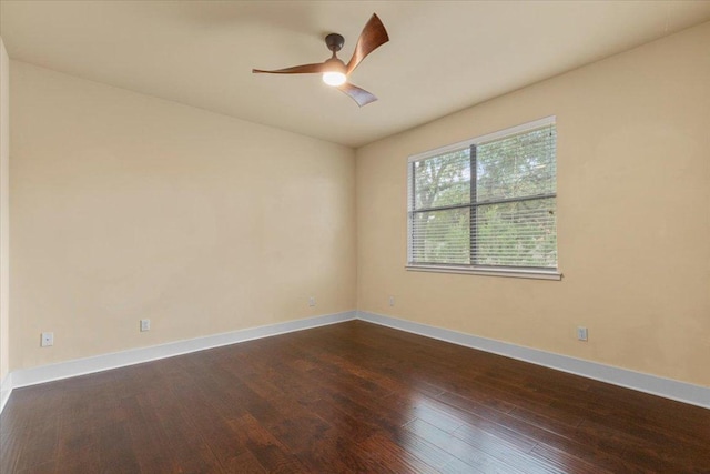 empty room featuring dark wood-style flooring, ceiling fan, and baseboards