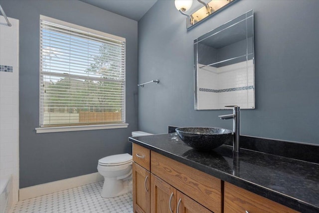 bathroom featuring toilet, vanity, bathtub / shower combination, and baseboards