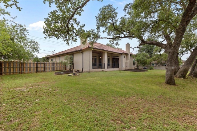 rear view of property featuring a chimney, a tiled roof, and stucco siding