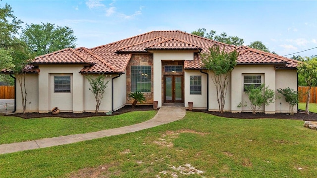 mediterranean / spanish home featuring french doors, a tile roof, and stucco siding