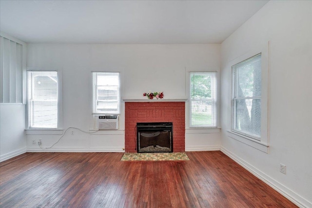 513 San Marcos Hwy, Luling, TX 78648 - unfurnished living room featuring dark wood-style flooring, a fireplace, and cooling unit