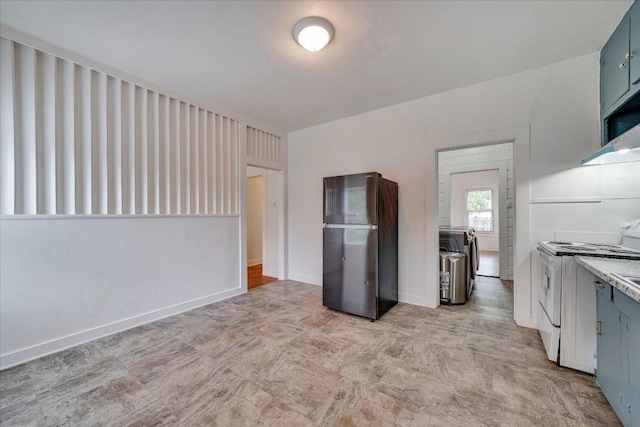 513 San Marcos Hwy, Luling, TX 78648 - kitchen with freestanding refrigerator, white electric stove, washing machine and dryer, light countertops, and blue cabinets