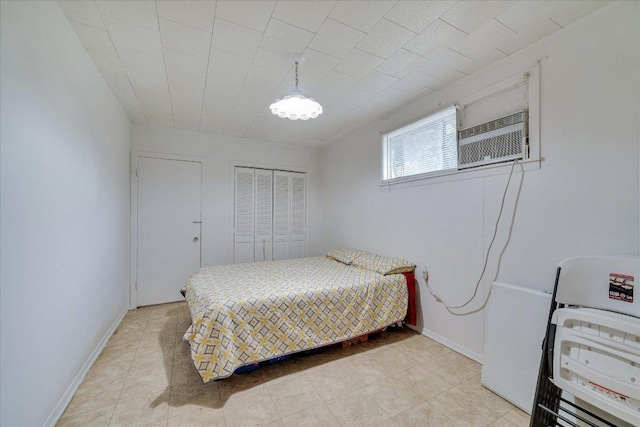513 San Marcos Hwy, Luling, TX 78648 - bedroom with a closet, a wall unit AC, and light tile patterned flooring