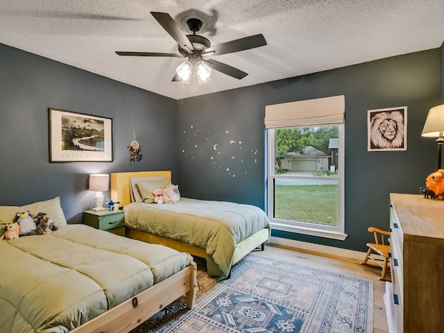6802 Rio Bravo Ln, Austin, TX 78737 - bedroom with wood finished floors, a textured ceiling, ceiling fan, and baseboards