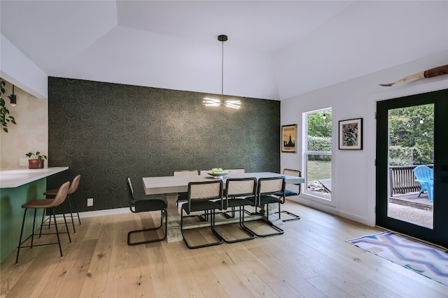 6802 Rio Bravo Ln, Austin, TX 78737 - dining room with wallpapered walls, light wood-type flooring, lofted ceiling, baseboards, and an accent wall