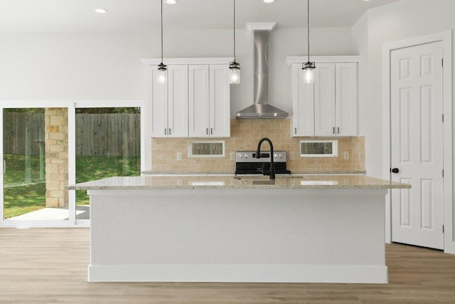 20405 Sunset Strip St, Lago Vista, TX 78645 - kitchen with wall chimney exhaust hood, an island with sink, light wood-style flooring, white cabinets, and backsplash