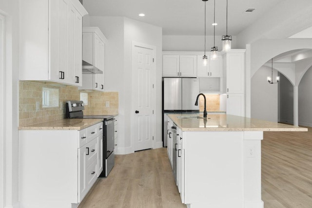 20405 Sunset Strip St, Lago Vista, TX 78645 - kitchen with electric stove, arched walkways, light wood-type flooring, white cabinetry, and an island with sink