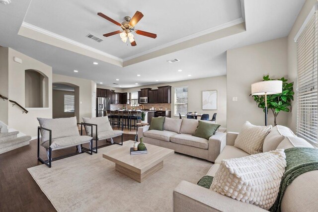 2020 Elaina Loop, Leander, TX 78641 - living area with a tray ceiling, light wood-style floors, ceiling fan, recessed lighting, and ornamental molding
