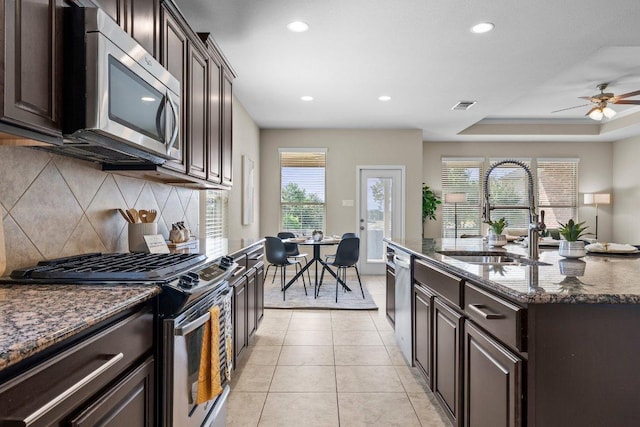 2020 Elaina Loop, Leander, TX 78641 - kitchen featuring appliances with stainless steel finishes, a sink, decorative backsplash, recessed lighting, and dark stone countertops