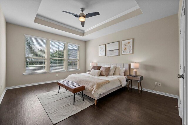 2020 Elaina Loop, Leander, TX 78641 - bedroom featuring a tray ceiling, dark wood-style floors, baseboards, ornamental molding, and a ceiling fan