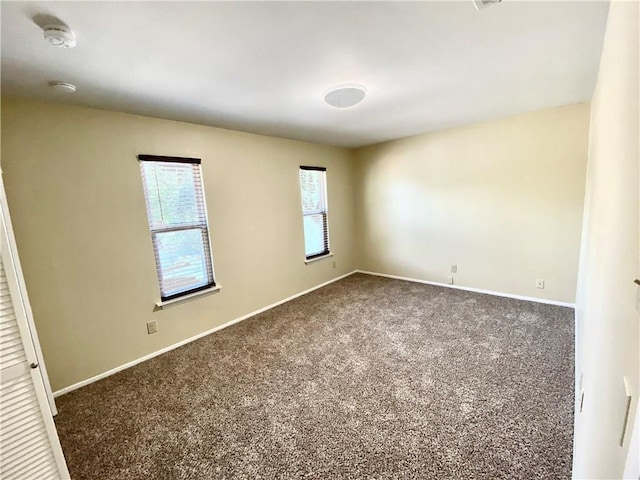 8502 Woodstone Dr, Austin, TX 78757 - spare room featuring dark carpet, a smoke detector, and baseboards