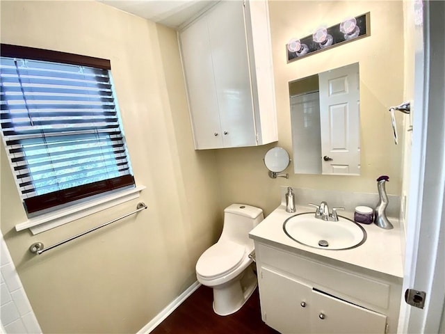 8502 Woodstone Dr, Austin, TX 78757 - bathroom with toilet, vanity, wood finished floors, and baseboards
