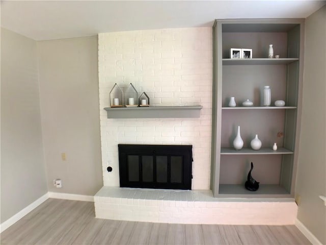 8502 Woodstone Dr, Austin, TX 78757 - unfurnished living room with wood finished floors, a fireplace, built in shelves, and baseboards