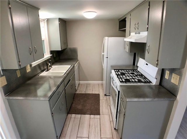 8502 Woodstone Dr, Austin, TX 78757 - kitchen with a sink, white appliances, gray cabinets, under cabinet range hood, and light wood-style floors