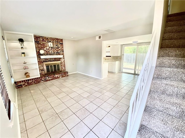 8502 Woodstone Dr, Austin, TX 78757 - unfurnished living room featuring light tile patterned floors, stairway, built in shelves, baseboards, and a brick fireplace