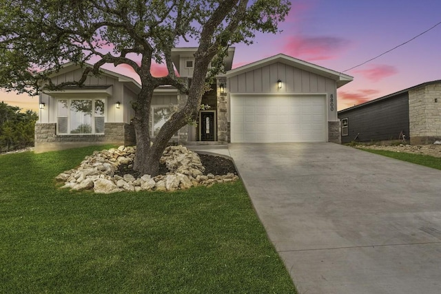 8800 Bar K Ranch Rd, Lago Vista, TX 78645 - view of front of home featuring stone siding, board and batten siding, driveway, a garage, and a lawn
