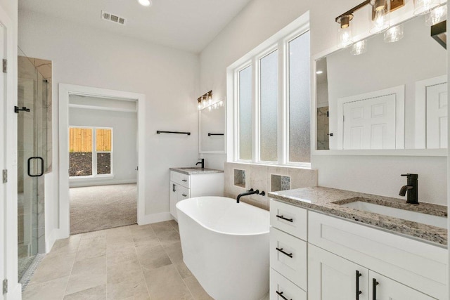 8800 Bar K Ranch Rd, Lago Vista, TX 78645 - bathroom with a shower stall, two vanities, a freestanding tub, and tile patterned floors