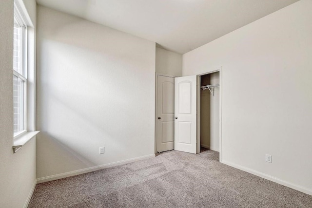 1174 Amy Dr, Kyle, TX 78640 - unfurnished bedroom with light carpet, multiple windows, and baseboards