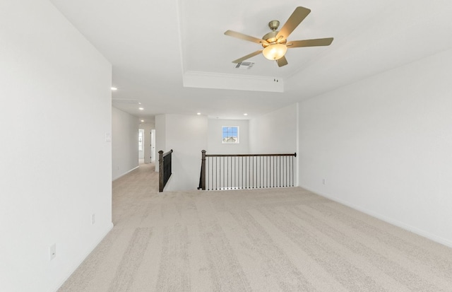spare room with a tray ceiling, carpet, recessed lighting, a ceiling fan, and baseboards