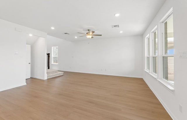 unfurnished room featuring healthy amount of natural light, ceiling fan, light wood finished floors, recessed lighting, and baseboards