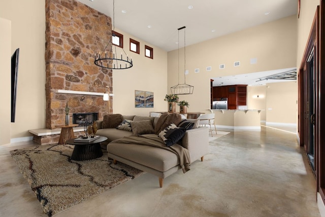 9208 Madrone Ranch Trl, Austin, TX 78738 - living area with finished concrete floors, a high ceiling, a fireplace, and baseboards