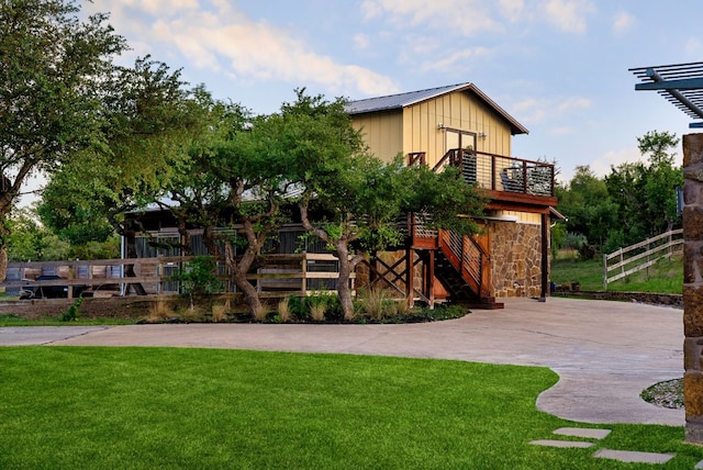 9208 Madrone Ranch Trl, Austin, TX 78738 - rear view of house featuring board and batten siding, stone siding, and stairs