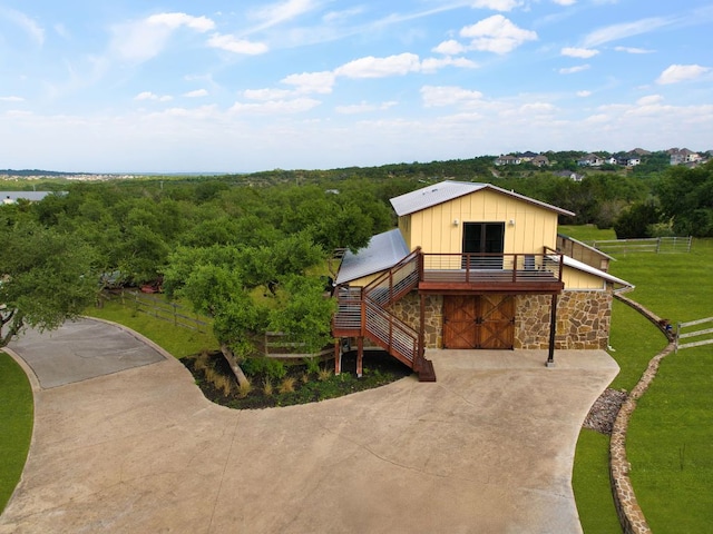 9208 Madrone Ranch Trl, Austin, TX 78738 - view of front of property with driveway, board and batten siding, stone siding, stairway, and a wooded view