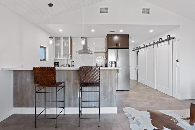 9208 Madrone Ranch Trl, Austin, TX 78738 - kitchen with stainless steel refrigerator with ice dispenser, wall chimney range hood, a kitchen breakfast bar, lofted ceiling, and a barn door