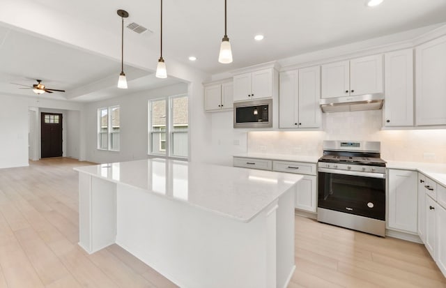 117 Crossbar St, Georgetown, TX 78633 - kitchen featuring stainless steel gas range oven, built in microwave, recessed lighting, decorative backsplash, and under cabinet range hood