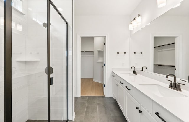 117 Crossbar St, Georgetown, TX 78633 - bathroom featuring a shower stall, double vanity, tile patterned flooring, a walk in closet, and baseboards