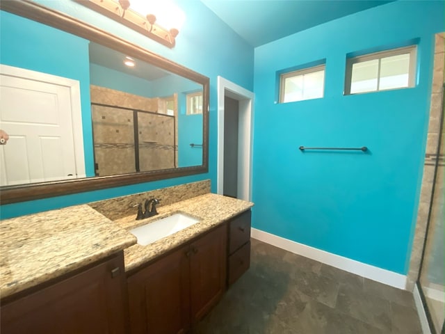 bathroom featuring a shower stall, vanity, and baseboards