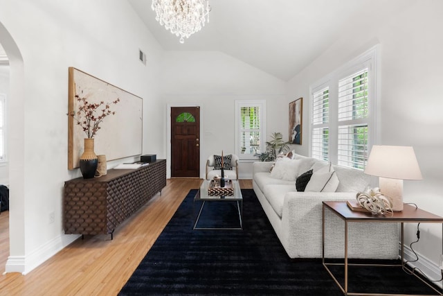 512 E 49th St, Austin, TX 78751 - living room featuring arched walkways, wood finished floors, vaulted ceiling, and a chandelier