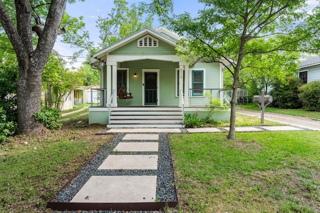 512 E 49th St, Austin, TX 78751 - shotgun-style home featuring covered porch and a front lawn