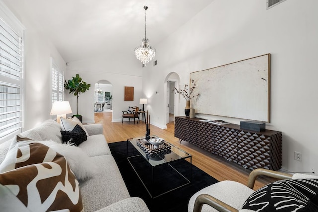 512 E 49th St, Austin, TX 78751 - living area featuring arched walkways, wood finished floors, a chandelier, and vaulted ceiling