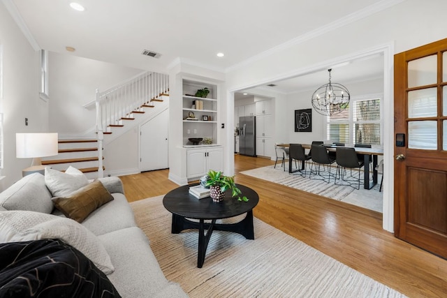 512 E 49th St, Austin, TX 78751 - living room with stairway, a chandelier, light wood-style flooring, ornamental molding, and recessed lighting