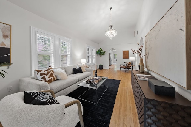 512 E 49th St, Austin, TX 78751 - living room with arched walkways, light wood-type flooring, a chandelier, and lofted ceiling