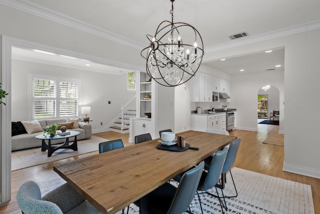 512 E 49th St, Austin, TX 78751 - dining area with arched walkways, stairs, crown molding, light wood-style flooring, and recessed lighting