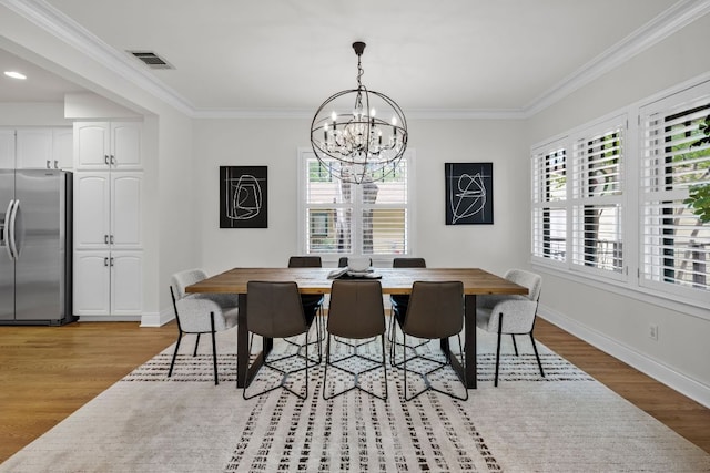 512 E 49th St, Austin, TX 78751 - dining area featuring light wood-style floors, a chandelier, and ornamental molding