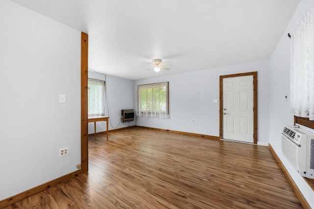 512 E 49th St, Austin, TX 78751 - unfurnished living room with a ceiling fan, wood finished floors, heating unit, and a wall mounted air conditioner