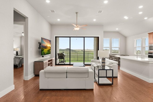 living area with a ceiling fan, baseboards, recessed lighting, wood finished floors, and vaulted ceiling