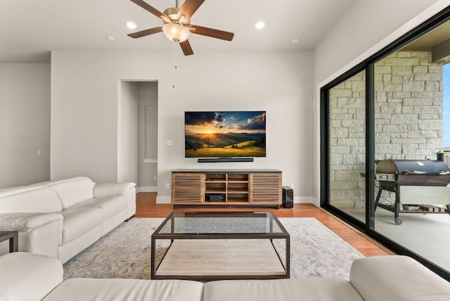 living area featuring a ceiling fan, wood finished floors, recessed lighting, and baseboards